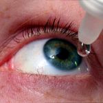 woman putting drops in eyes