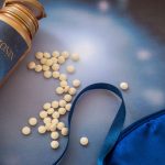 Melatonin supplements and sleep mask on the blue background