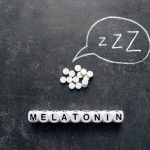 White pills in Z shape and text. Sleeping pills, hypnotic drugs, sedative, melatonin on dark night background