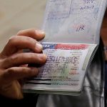 FILE PHOTO: A member of the Al Murisi family, Yemeni nationals who were denied entry into the U.S. because of the travel ban, shows the cancelled visa in their passport at Washington Dulles International Airport in Chantilly